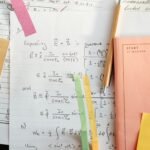 Detailed math notes with handwritten equations and colorful papers, perfect for educational use.